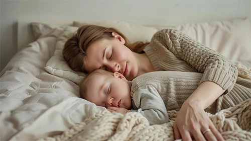 Neonato nel lettone che dorme con la mamma