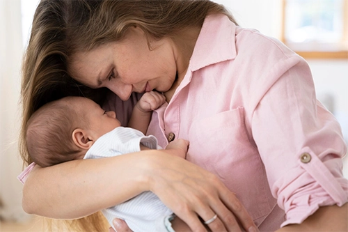 Mamma che consola neonato con le coliche