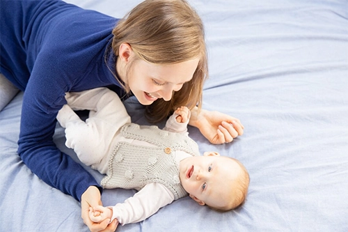 mamma tasta le mani fredde del neonato, mentre giocano